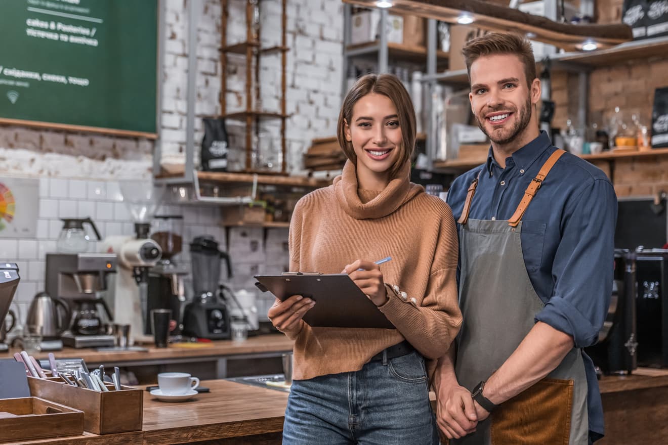 Restaurant owners together behind the counter of their café