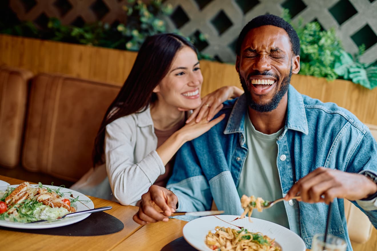 Couple laughing together over their restaurant meal